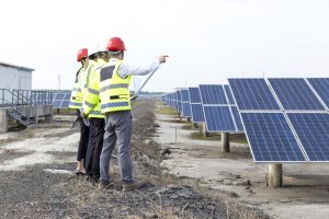 Technicians and developers looking at solar O&M plans at a solar project